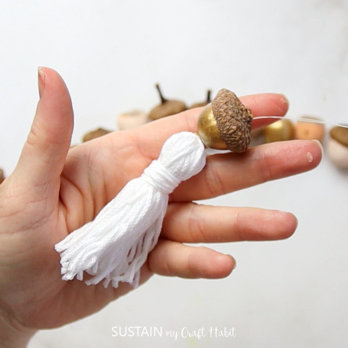 Adding a tassel to the end of the acorn garland.
