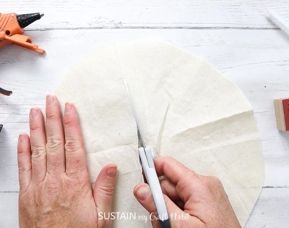 Cutting a slit into the circle canvas fabric.