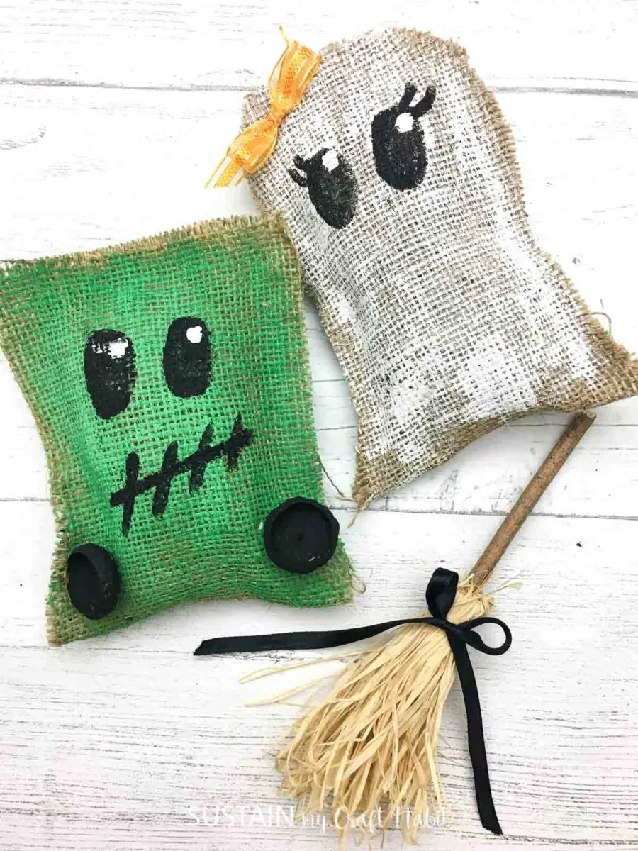 Decorative Halloween stuffies made as a ghost and Frankenstein's monster next to a mini witches broom.