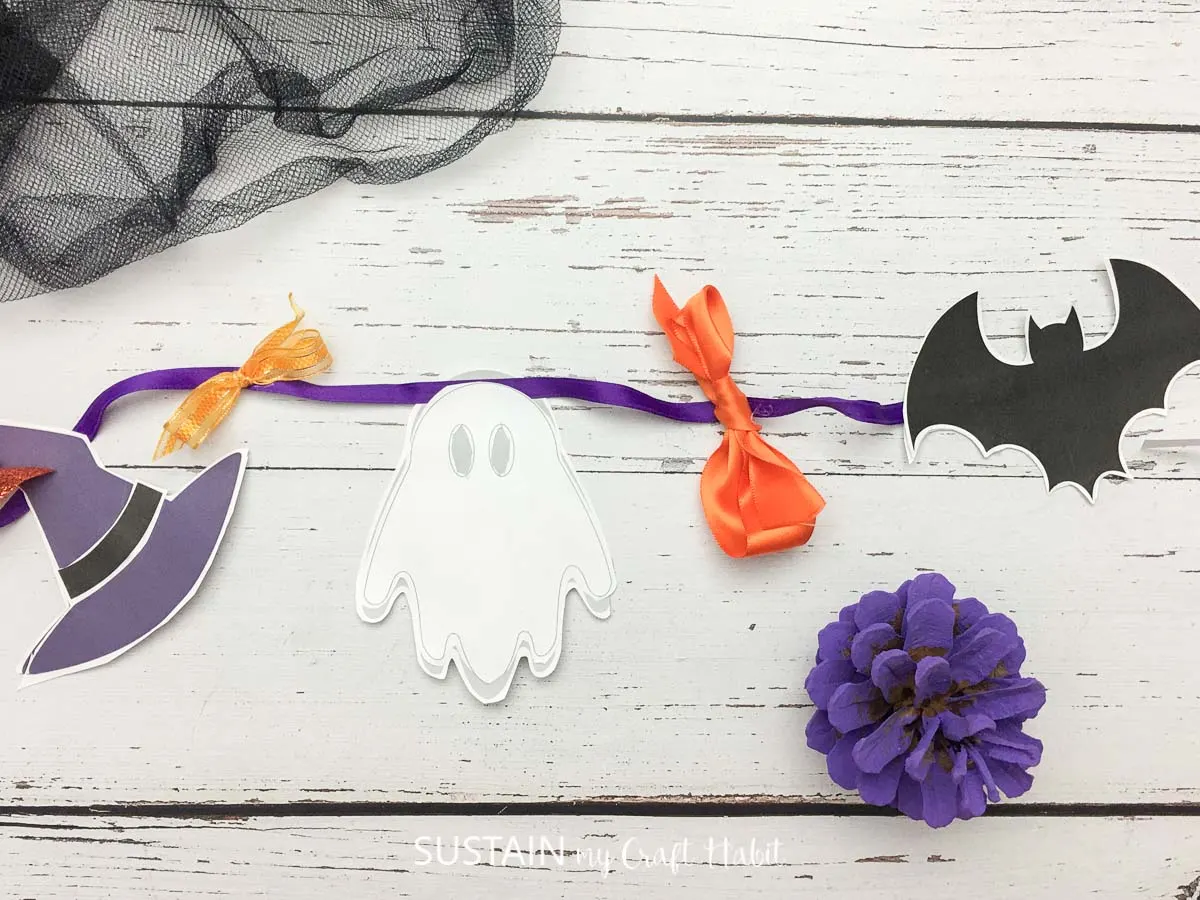 Halloween paper garland attached with purple ribbon.