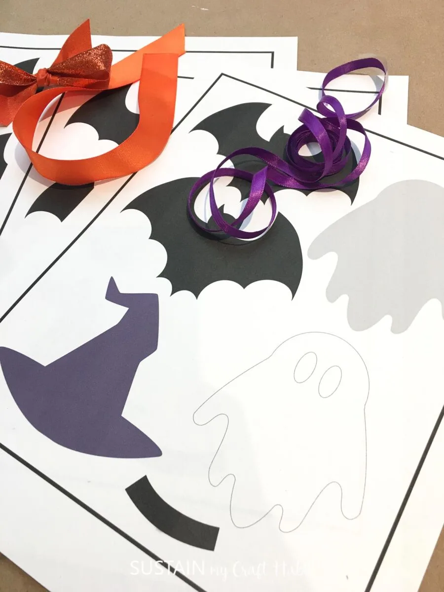 Materials needed for Halloween paper garland including a Halloween printable, ribbon and glue.