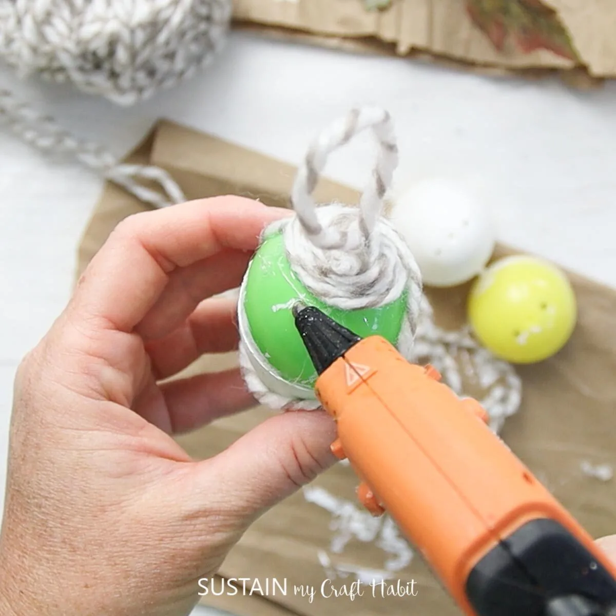 Adding hot glue around on the plastic egg.