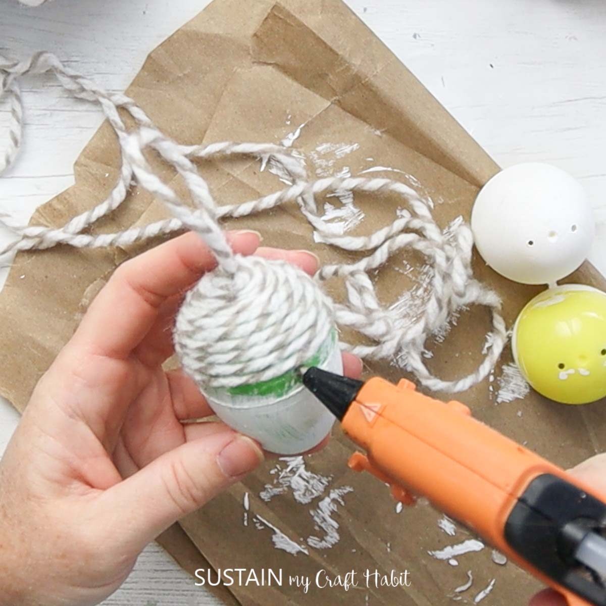 Adding glue on the middle of the plastic egg.
