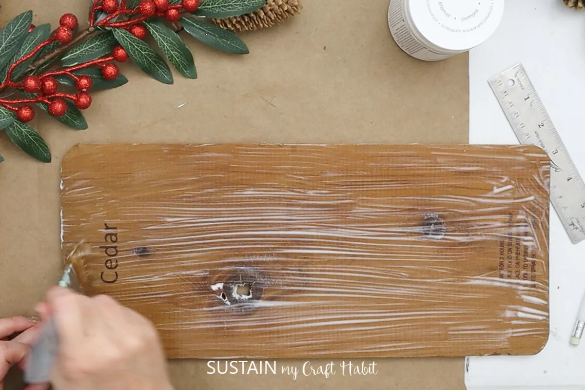 Covering a cedar plank with glue.