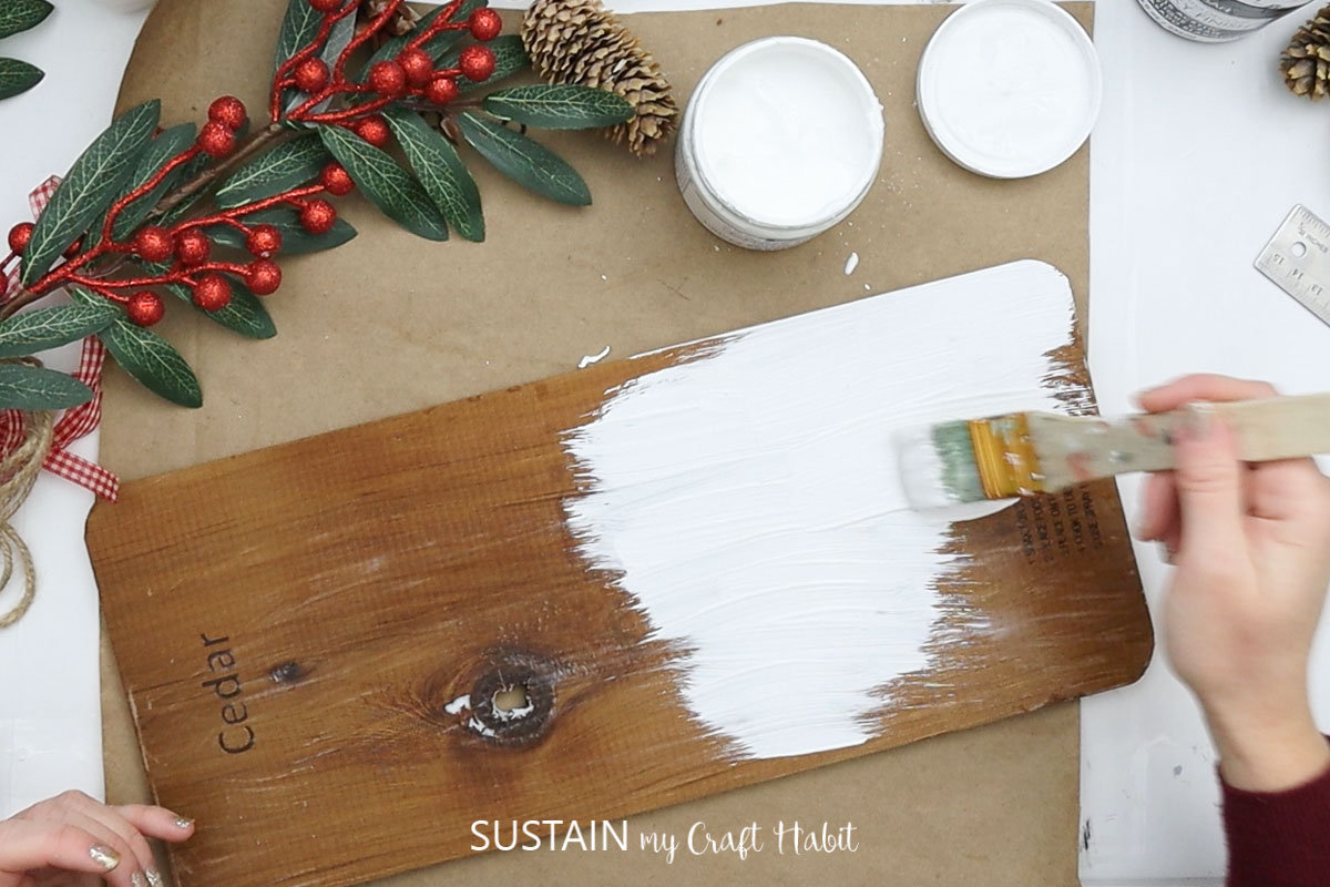 Painting a cedar plank white.