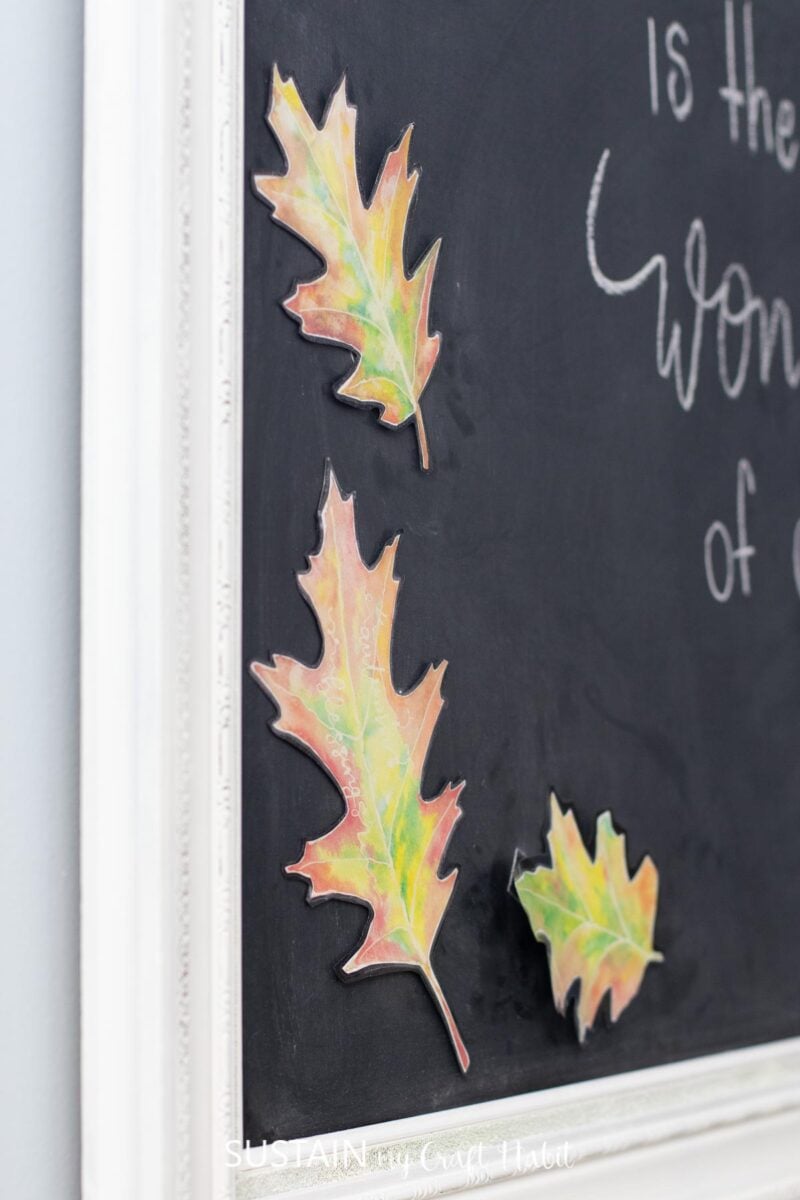 Attaching leaves to the framed chalkboard wall art.
