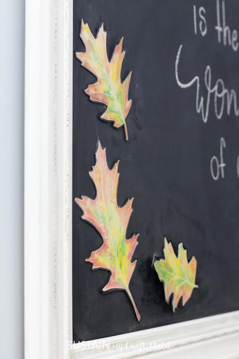 Attaching leaves to the framed chalkboard wall art.