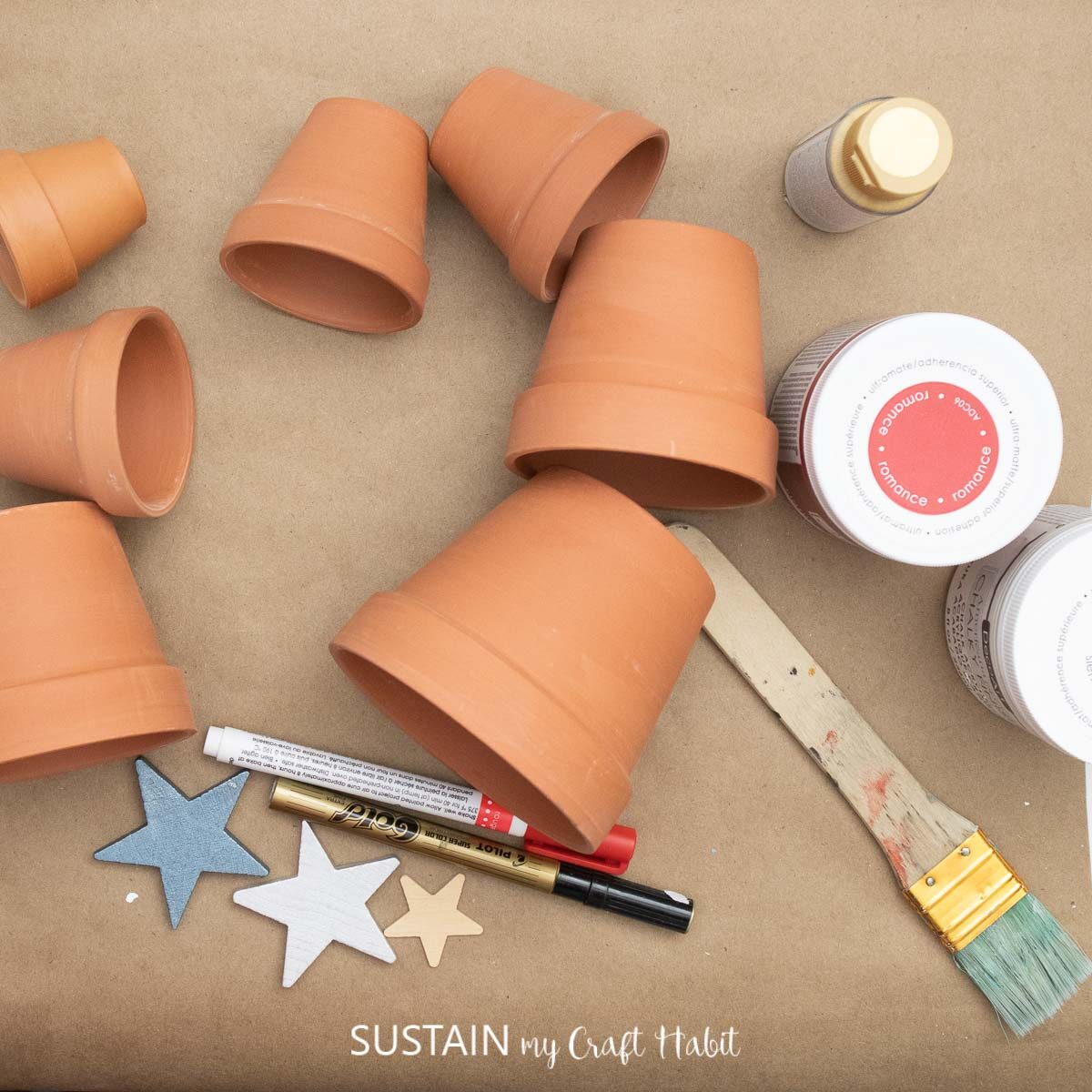 Materials need to make stacked trees including terracotta pots, paint, paint brush and embellishments.