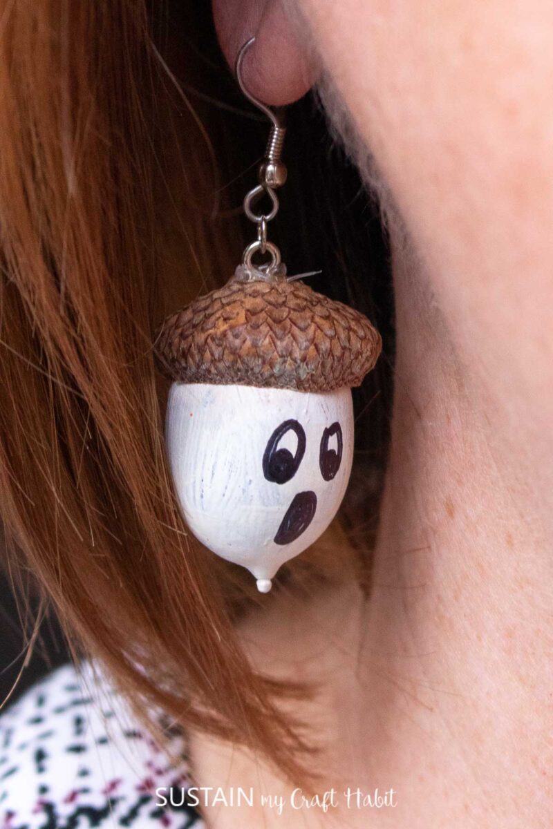Woman wearing an acorn earring.