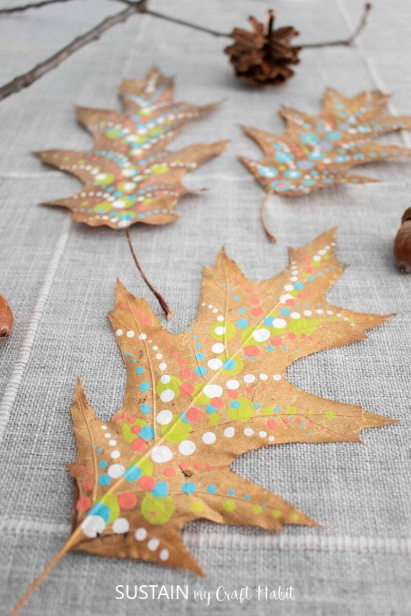 Painted pressed leaves laying on a table.