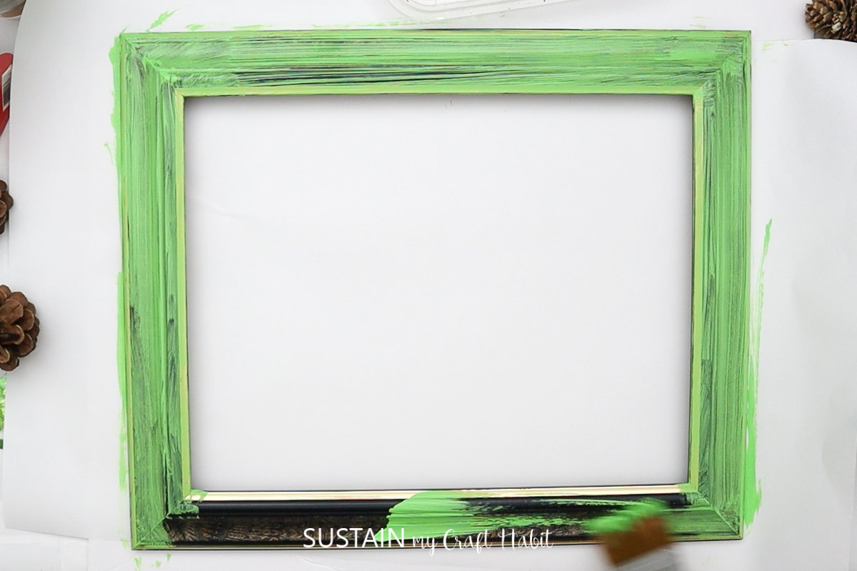 Painting a picture frame green.