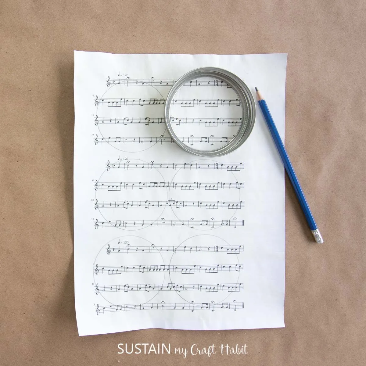 Drawing circles on a music sheet using a canning lid to trace.