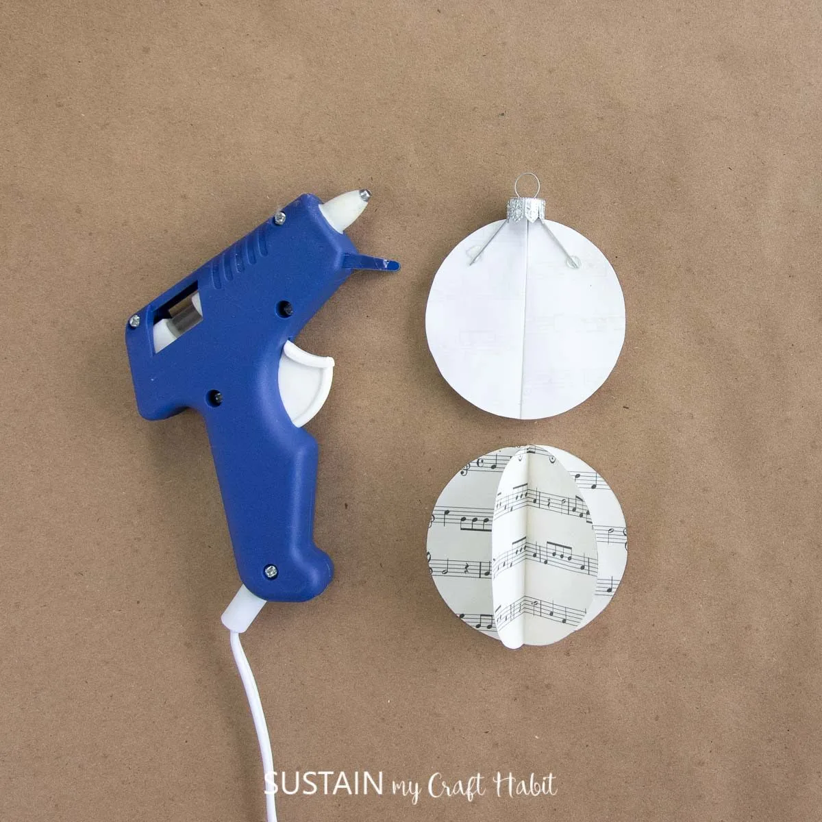 Using hot glue to attach an ornament cap to the half circle ornament sheets.