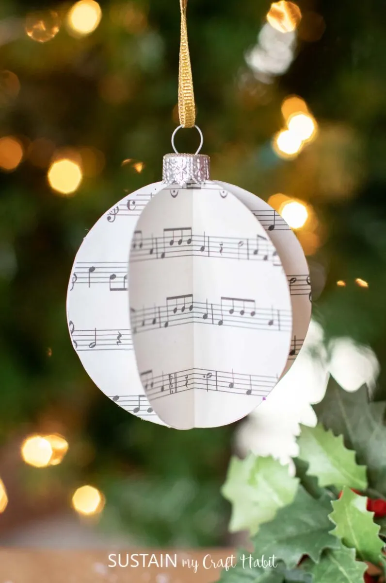 3D sheet music ornament hanging on a tree.