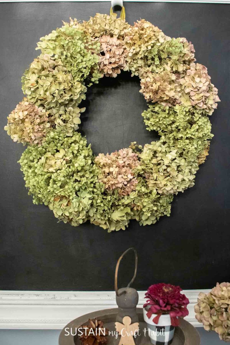 DIY dried hydrangea wreath hung on chalkboard.