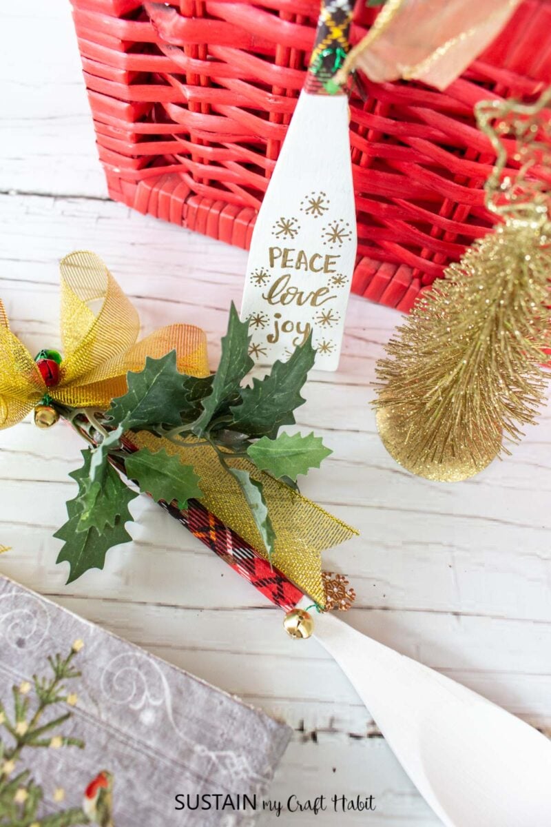 Decorated wooden spoons next to a mini Christmas tree.