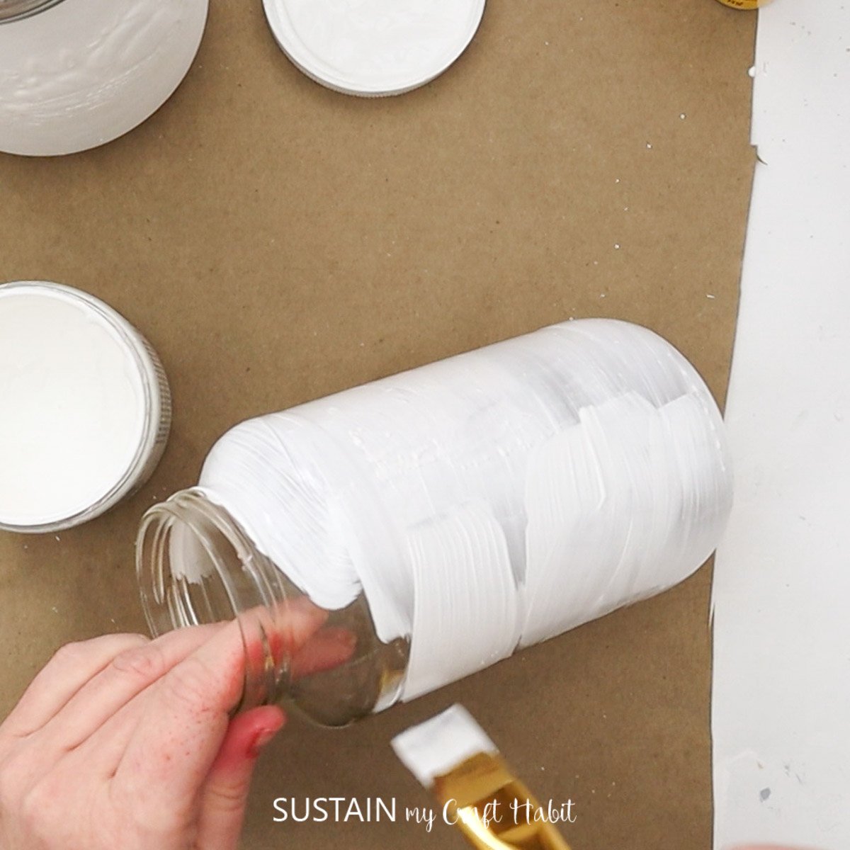 Painting a mason jar white.