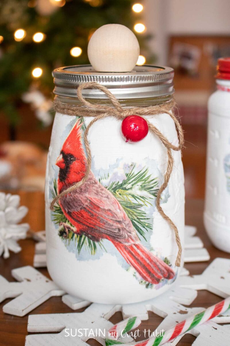 Holiday mason jars with decoupage bird napkins, twine and decorative knob.