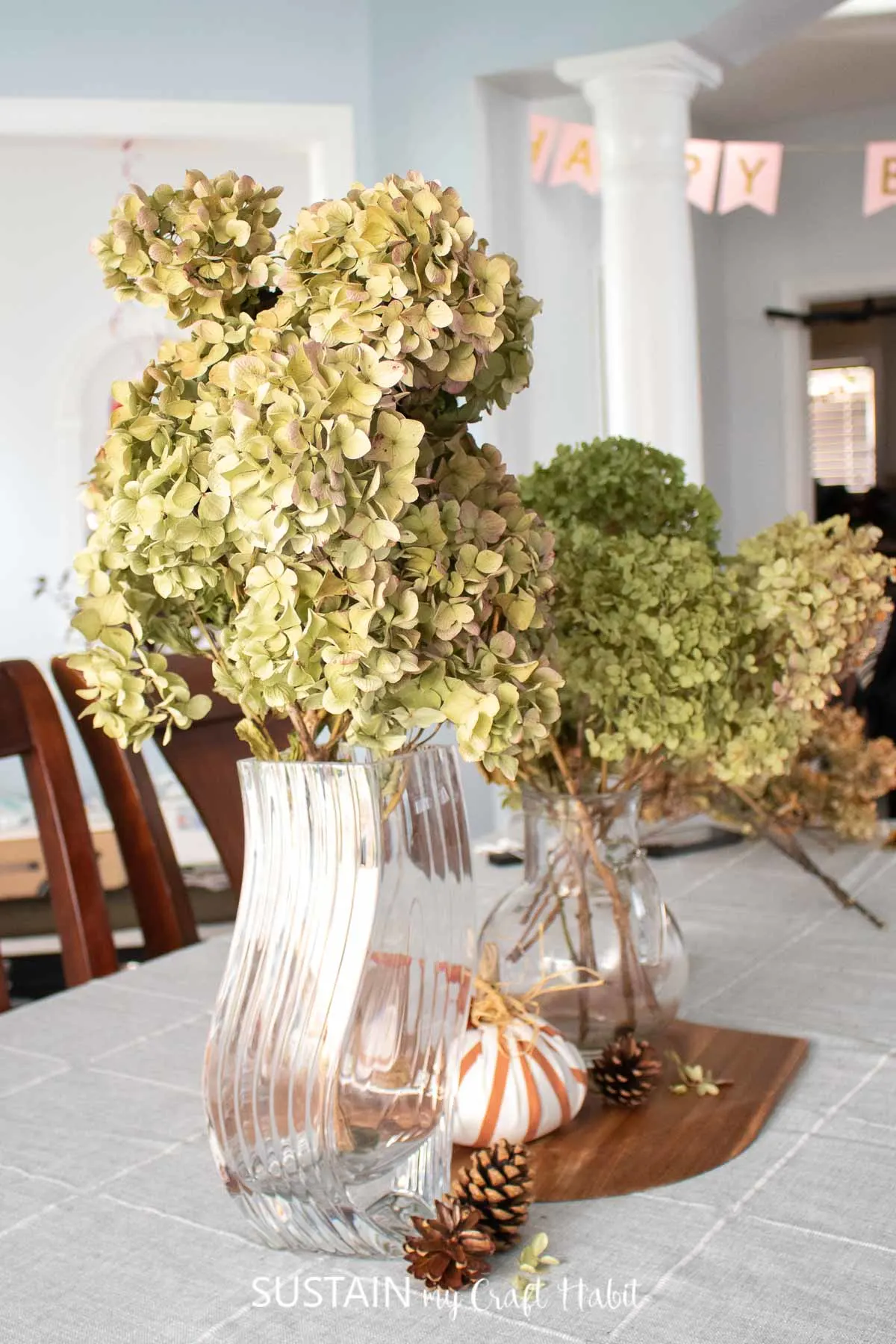 Dried hydrangeas in vases set on a table.