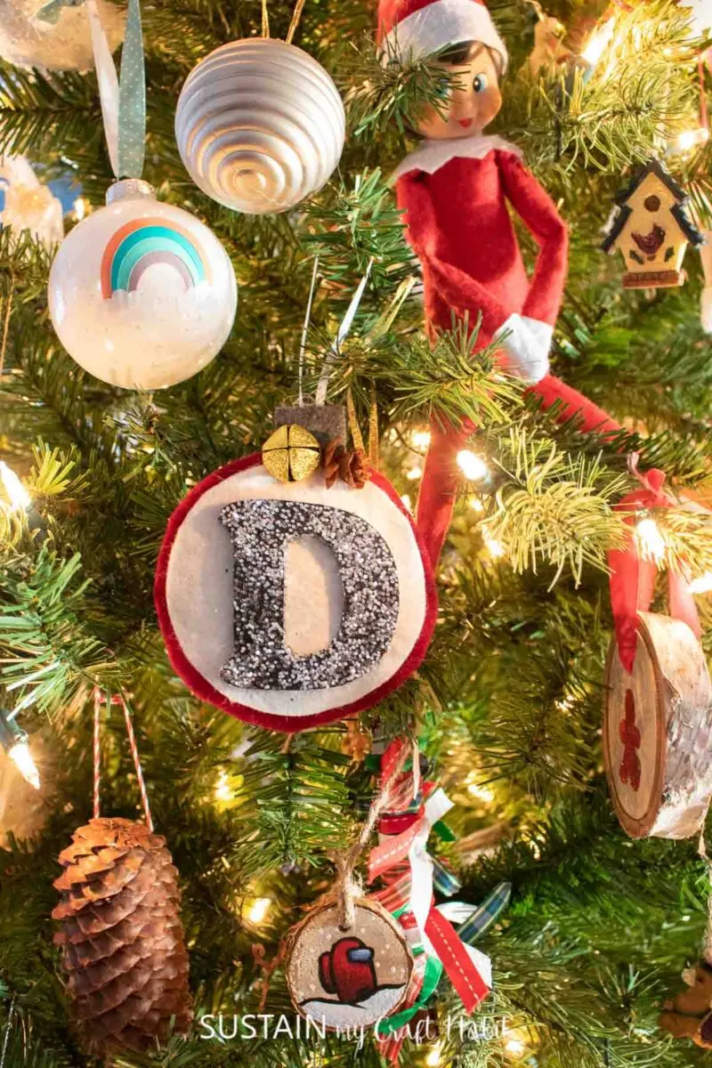 Felt monogram ornament hanging in a Christmas tree.