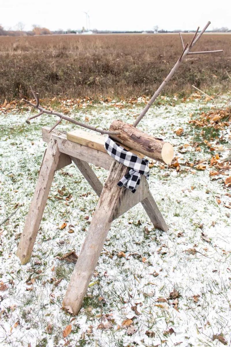 Repurposed sawhorse wood reindeer with a scarf.