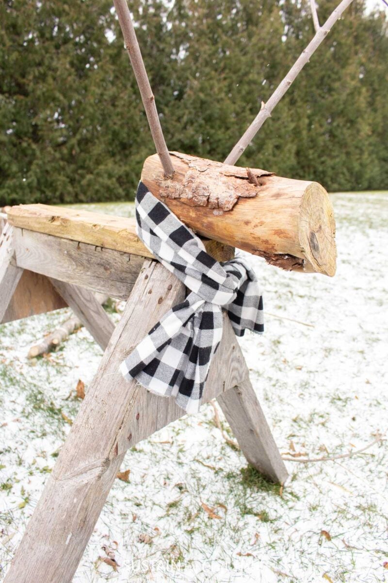 Attaching a scarf to the repurposed sawhorse wood reindeer.
