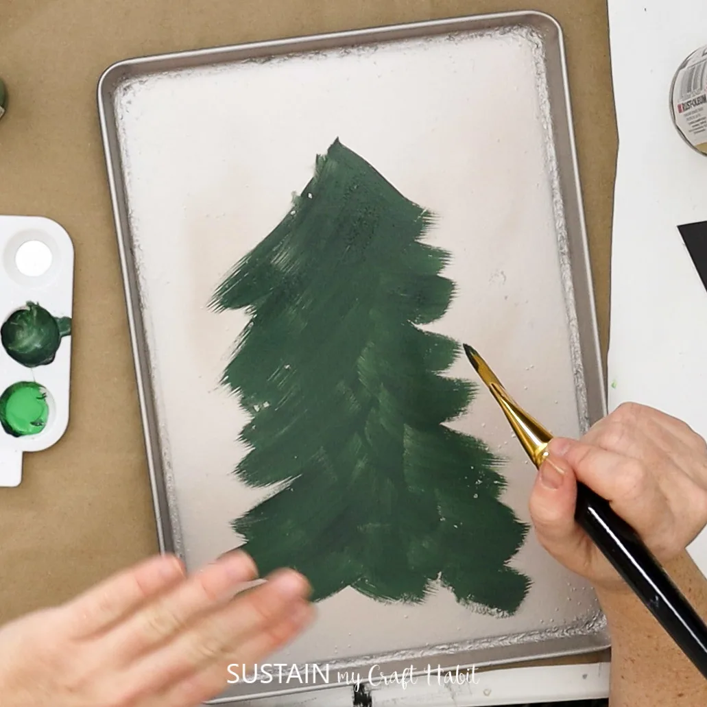Painting a Christmas tree onto a cookie sheet.