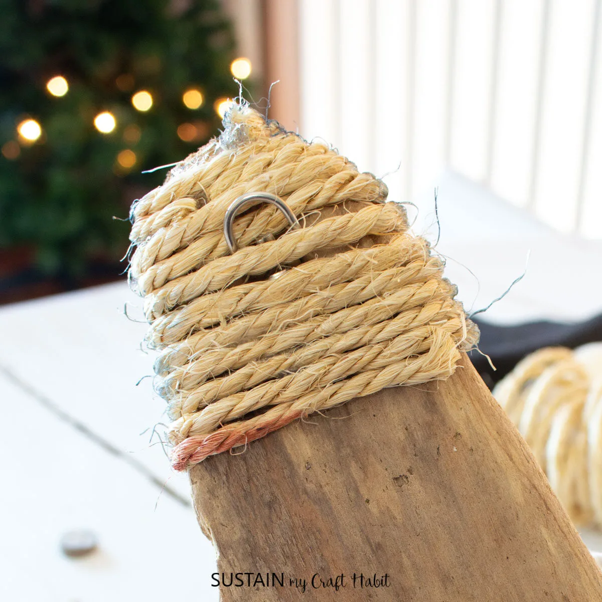 Wrapping sisal rope on the top of a piece of driftwood.