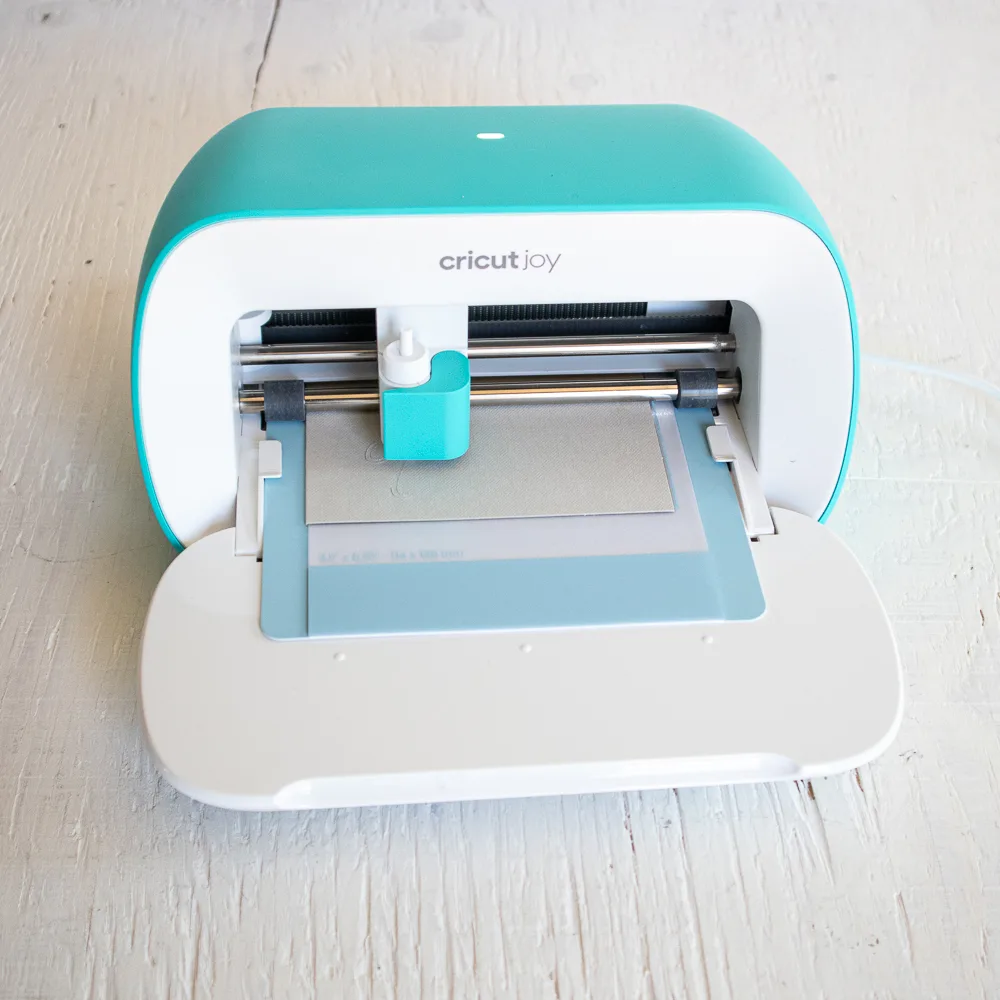 Cricut Joy machine cutting a design into the card stock.