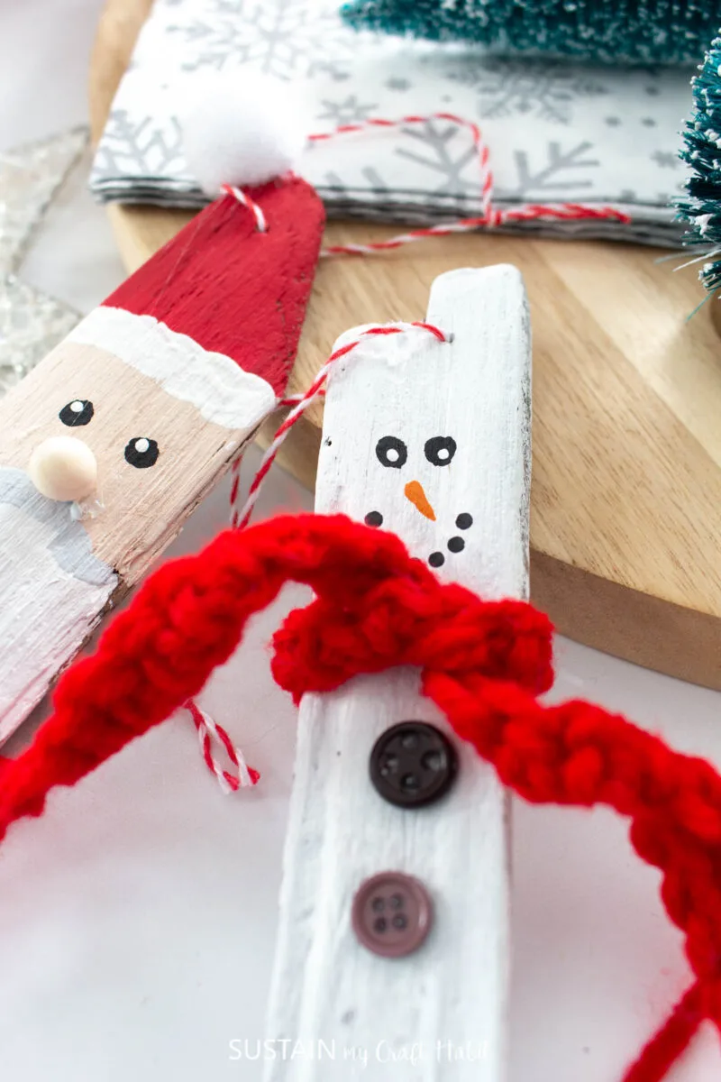Close up of knitted mini scarf wrapped around a driftwood snowman.