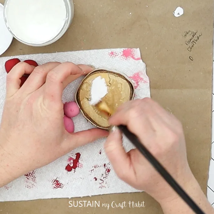 Painting birch wood slice with white paint.