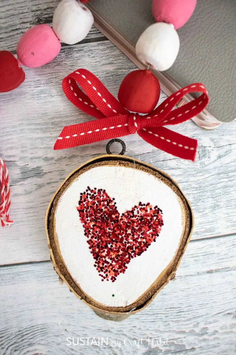 Birch wood slice painted white with a  red heart.