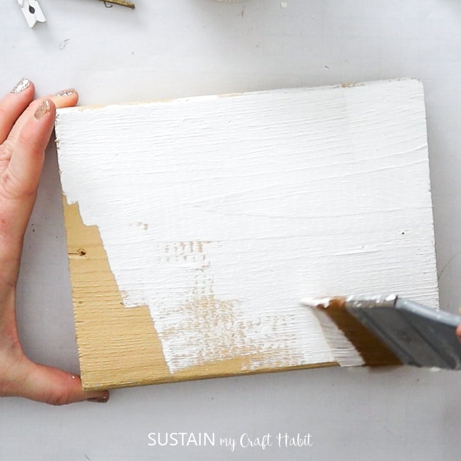 Painting a block of wood white.