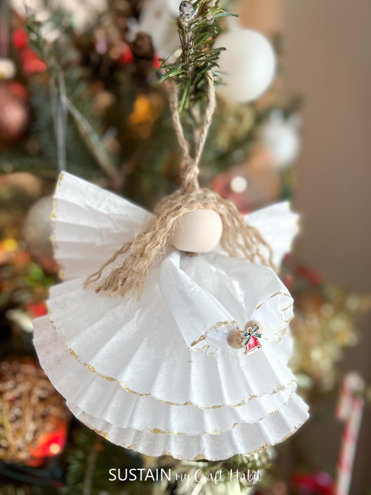 Finished coffee filter angel craft hung on a Christmas tree.