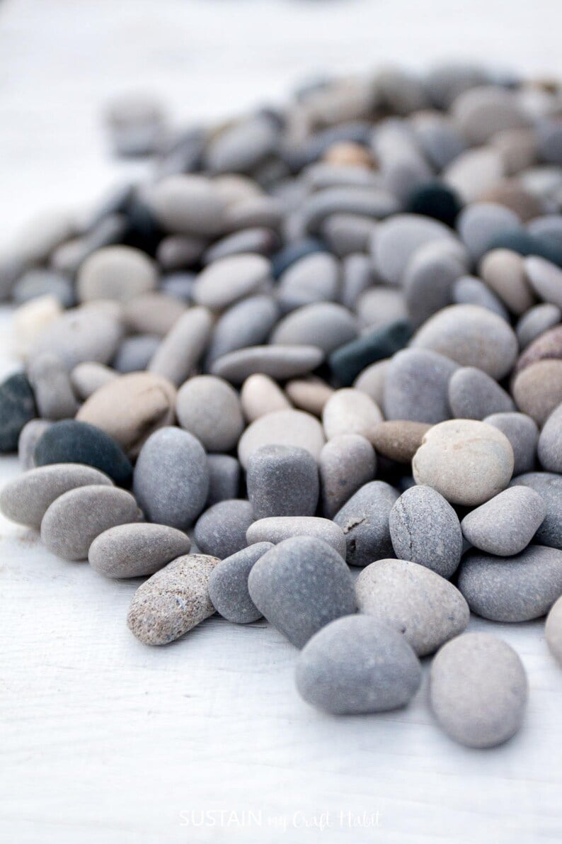Close up view of small beach stones in various shades of grays and taupe.
