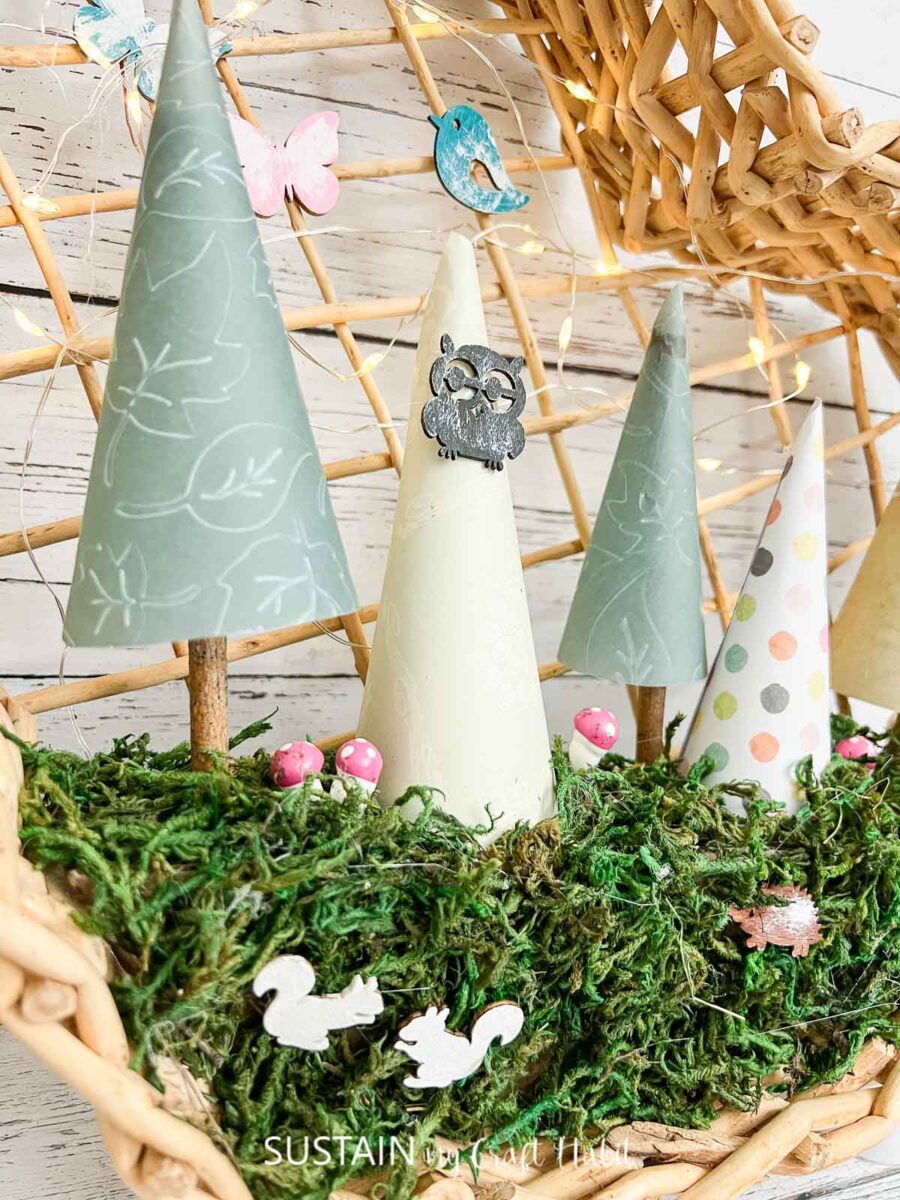 Close up of paper trees with woodland cutouts and fairy lights.