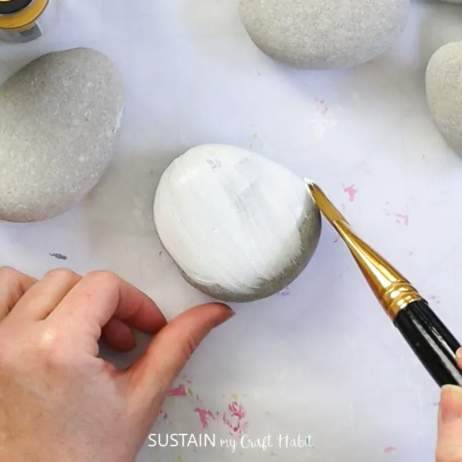 Painting a rock white.