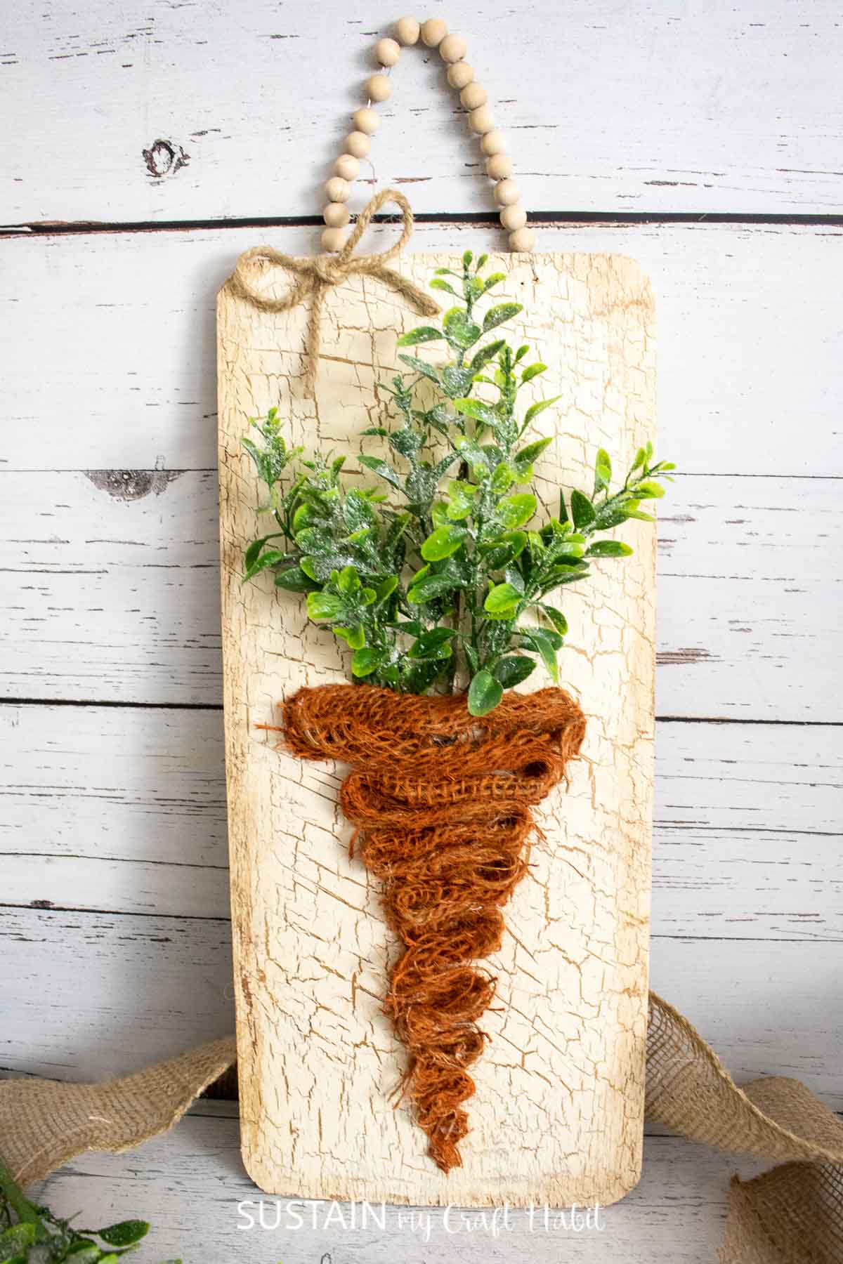 Cedar plank carrot sign made from burlap and faux greenery.