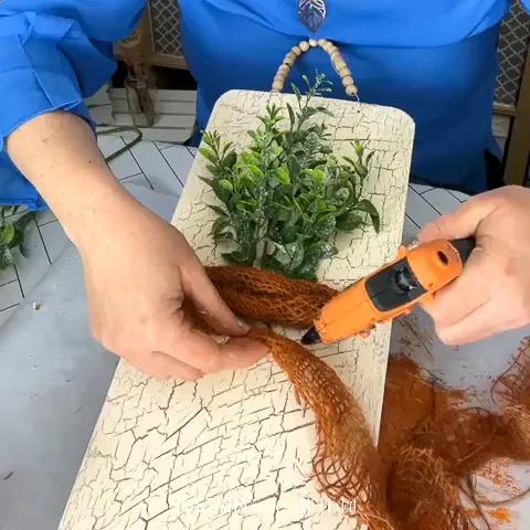Gluing painted burlap to form a carrot shape.