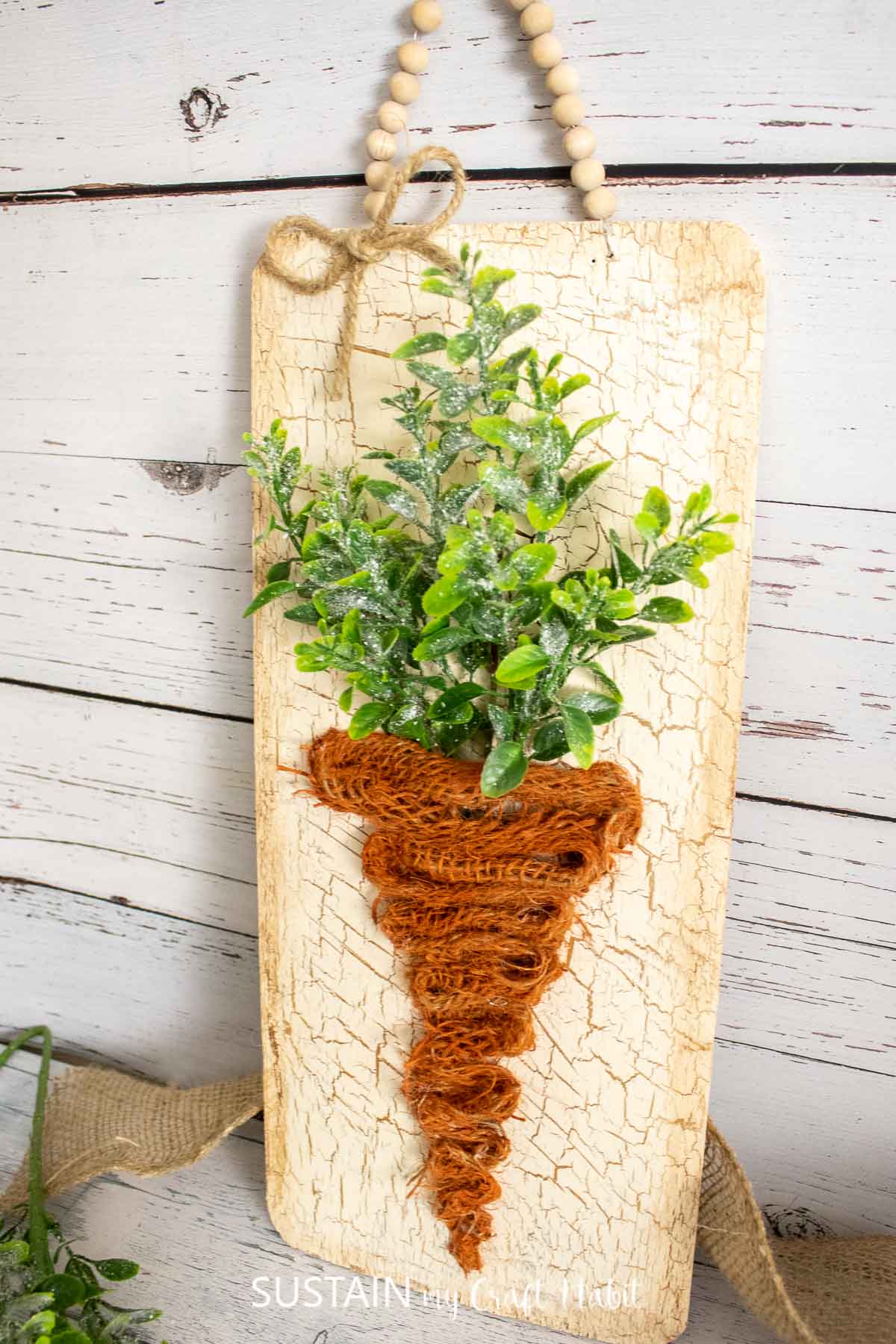Cedar plank carrot sign made from burlap and faux greenery.