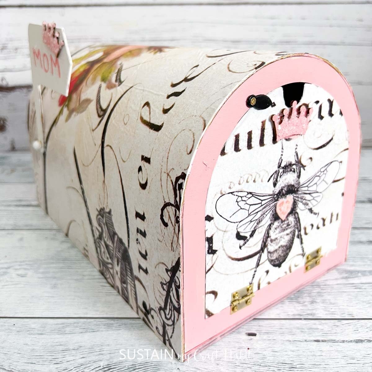 Memory mailbox painted pink and decoupaged with decorative paper.