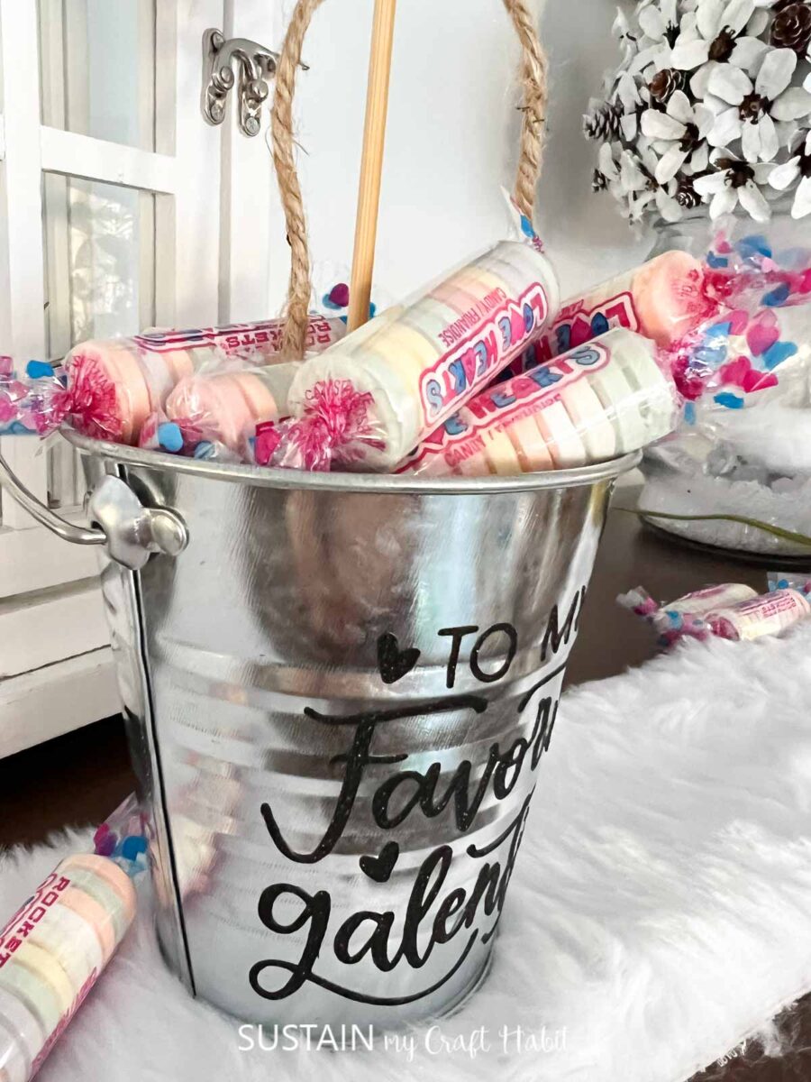 Metal bucket with vinyl lettering filled with candy.