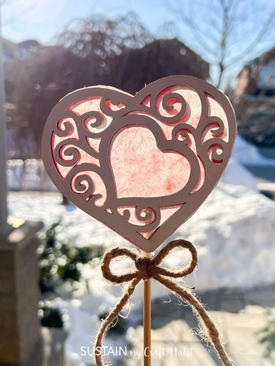 Wood heart cutout attached to a wooden dowel with twine.