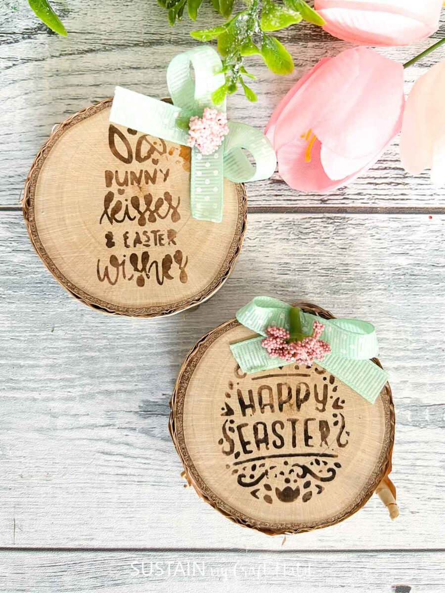 Lettering on wood slices using a wood burning pen and placed next to a tulip and bows.