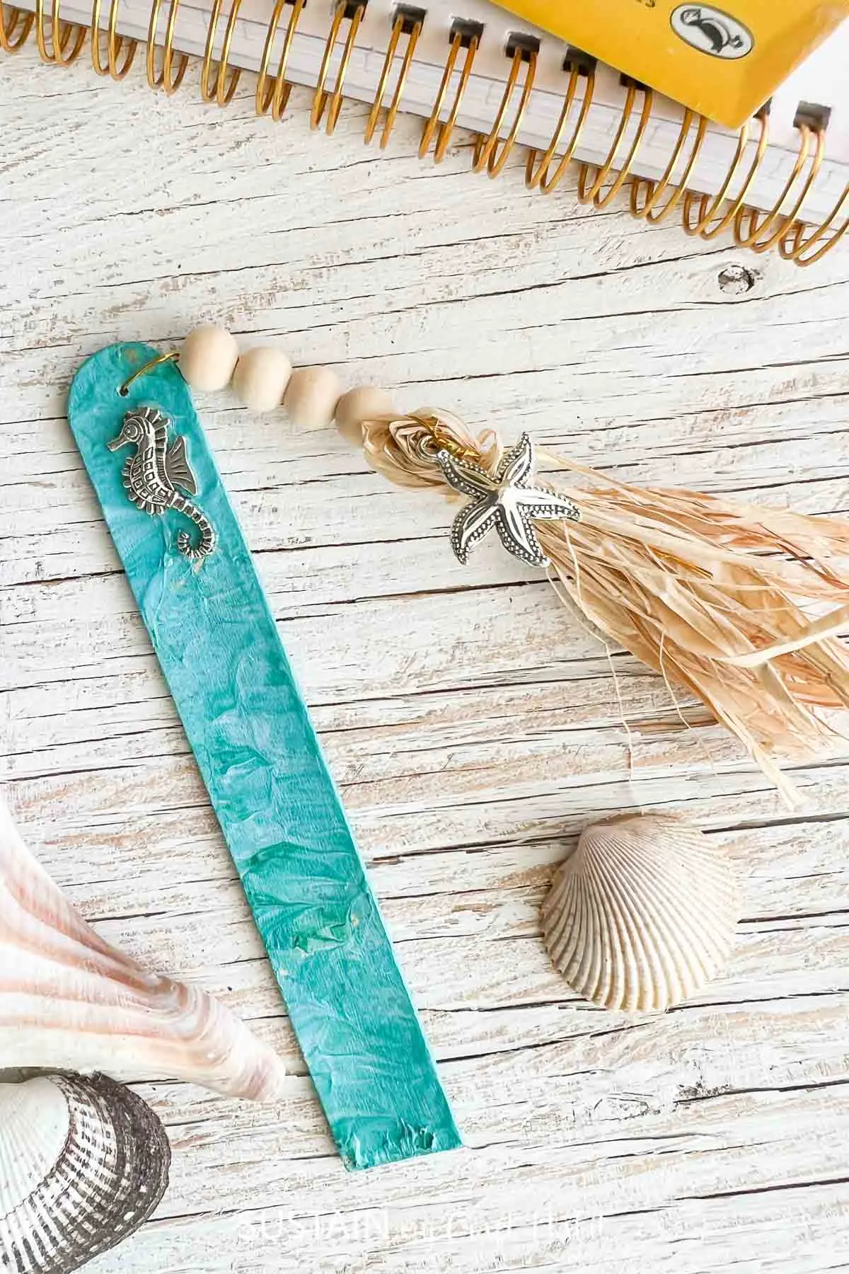 Paint poured beachy bookmark made with beach charms, wood beads and a tassel.