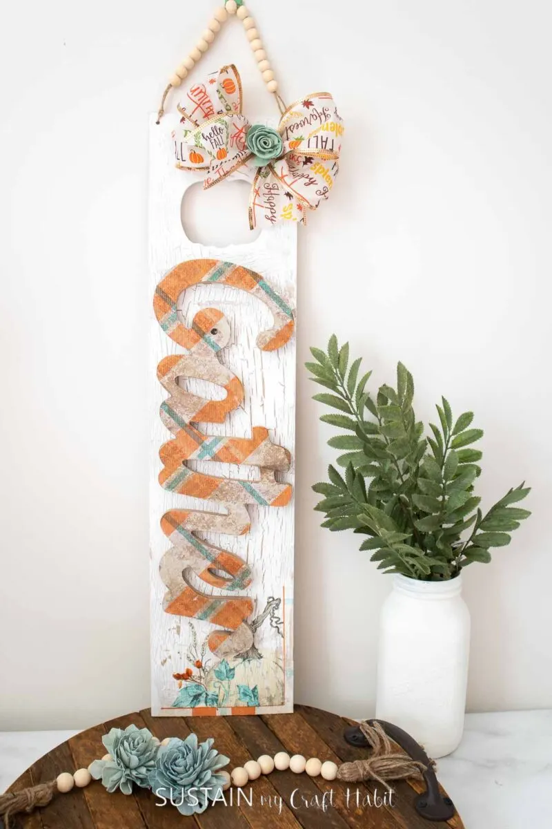 Gather sign for fall with decoupage wood sign, painted wood plank, ribbon, flowers and wood beads.