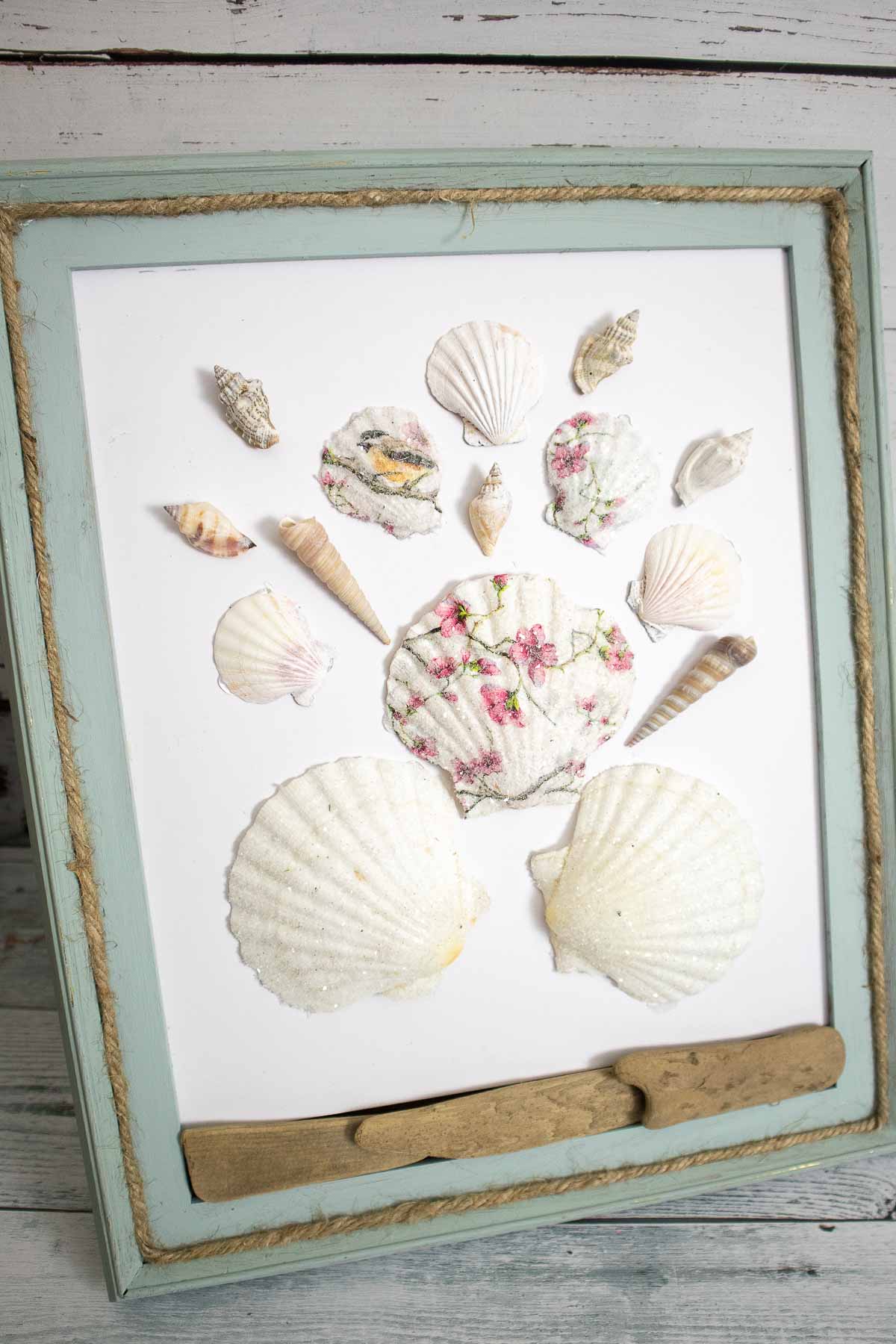 Decoupage seashells using paper napkins and decorated with driftwood, twine on a painted frame.