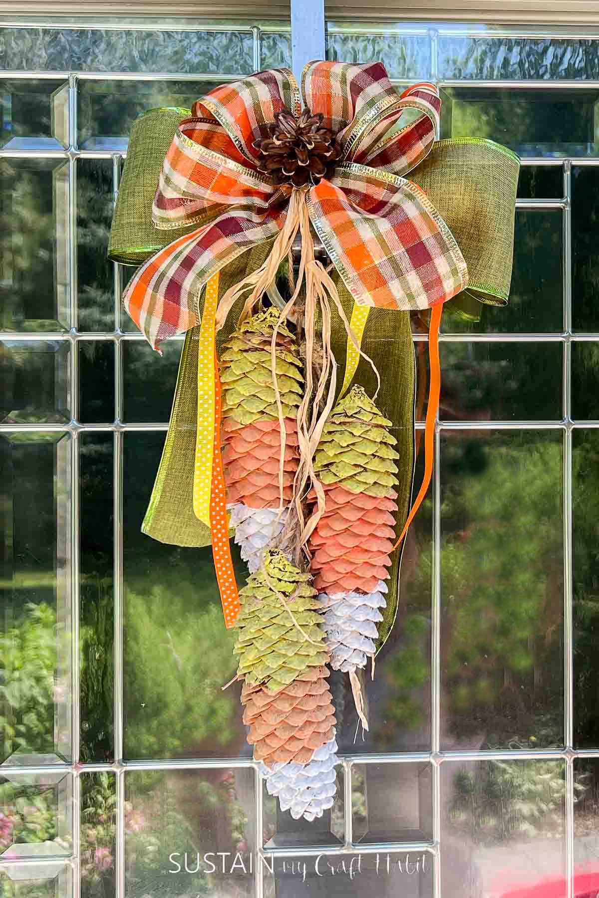 Candy corn decor made from painted pine cones and ribbon.