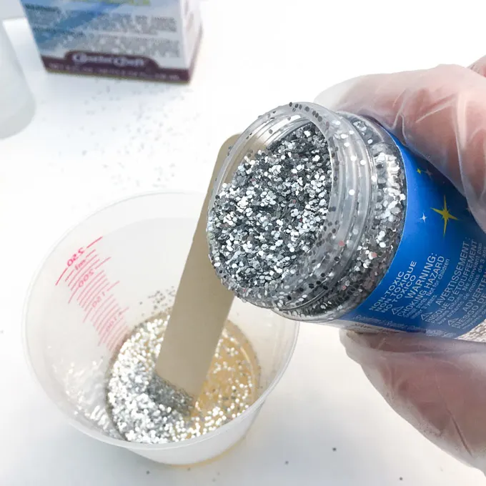 Adding silver glitter into the mixing cup.