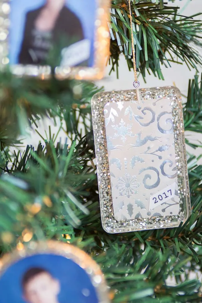 Personalized resin ornament hung on a Christmas tree.